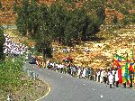 Color guard, riflemen, and religious leaders at the front of a funeral procession, Ethiopia