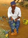 Sierra Leone, man repairing fishing net