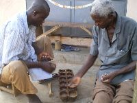 Ouidah, Benin, men playing seed game.