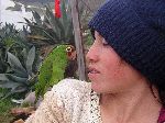 Girl standing by the road with a parakeet