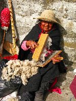 Ecuador, Salasaca: Woman carding or combing wool
