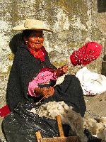 Ecuador, Salasaca: Woman spinning wool yarn