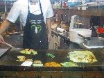 Cook preparing modeum jeon -- assorted pancakes.